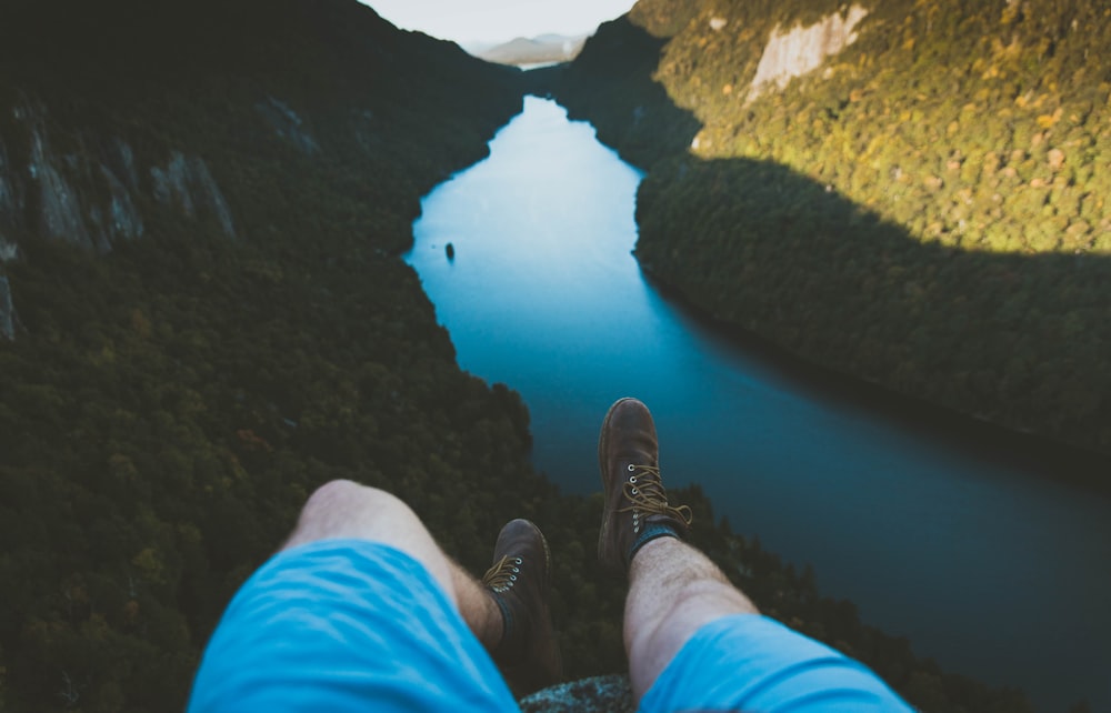 person laying on mountain edge