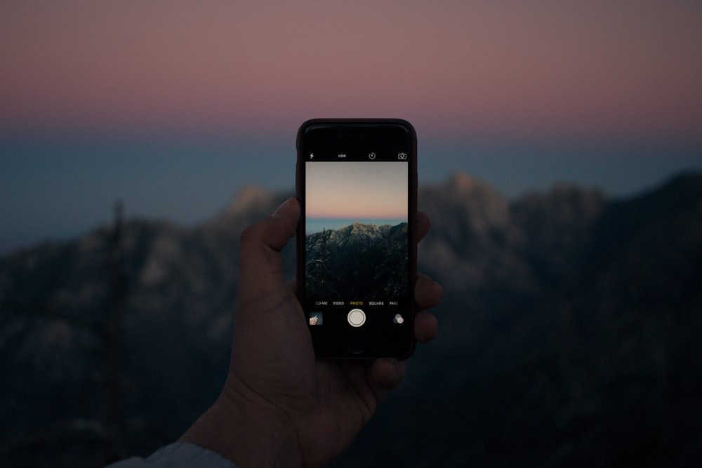 iPhone을 사용하여 사진을 찍는 사람의 선택적 초점 사진