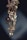 An elegant piece of jewelry featuring floral designs with intricate metalwork and adorned with pearls and gemstones. The craftsmanship is delicate, with attention to detail in the arrangement of the flower petals and leaves.