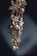 An elegant piece of jewelry featuring floral designs with intricate metalwork and adorned with pearls and gemstones. The craftsmanship is delicate, with attention to detail in the arrangement of the flower petals and leaves.
