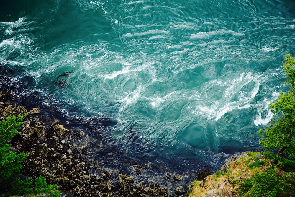 bird's-eye view photography of body of water smashing the rocks