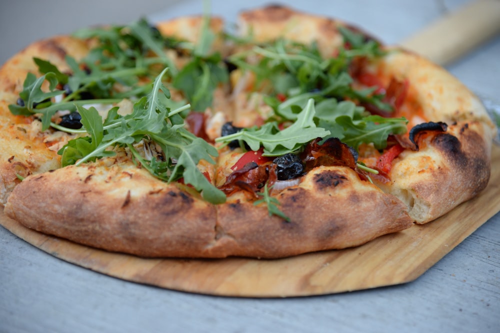 Pizza de calabresa com coberturas de folhas verdes