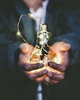 man holding incandescent bulb