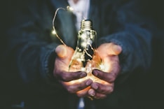 man holding incandescent bulb