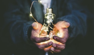 man holding incandescent bulb