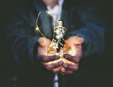 man holding incandescent bulb