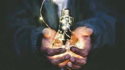 man holding incandescent bulb