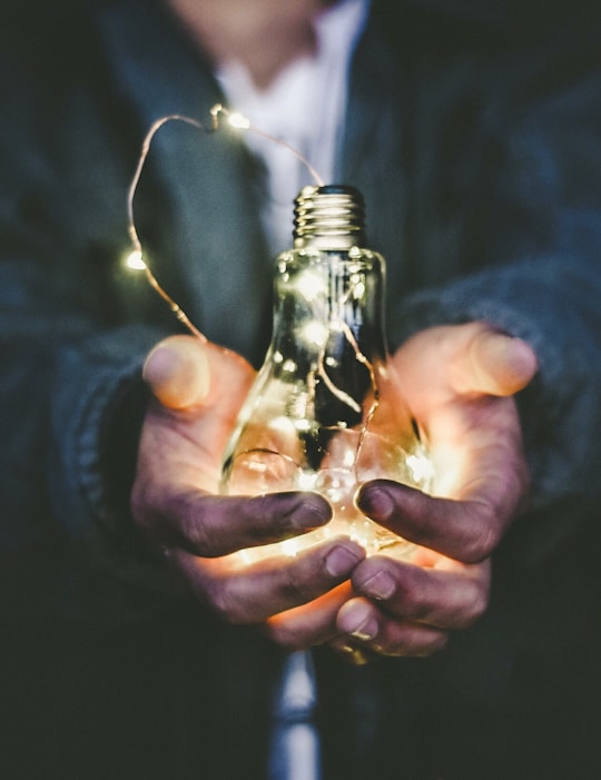 man holding incandescent bulb