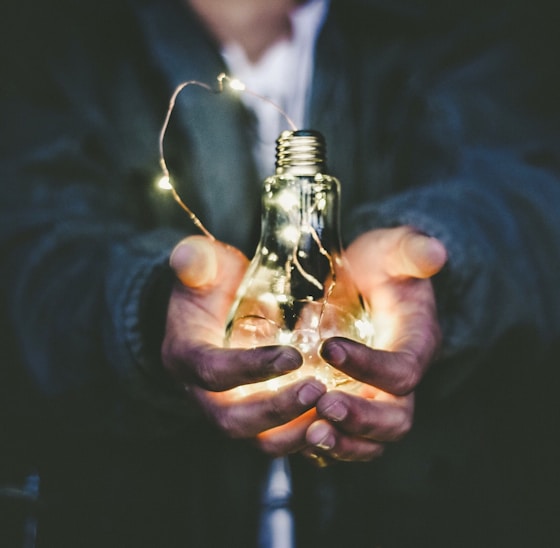 man holding incandescent bulb