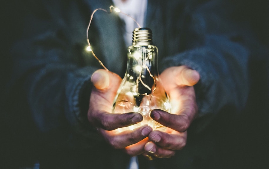 man holding incandescent bulb