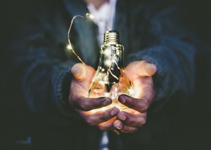 man holding incandescent bulb