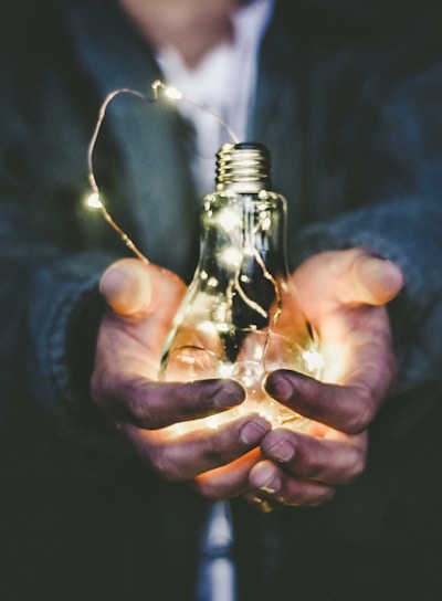 man holding incandescent bulb