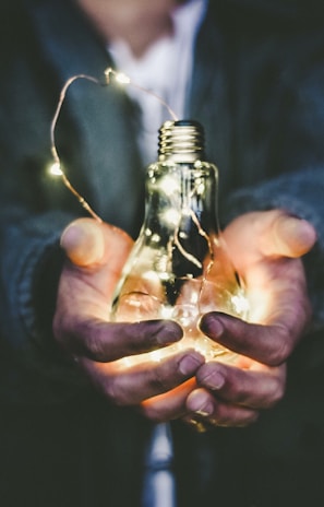 man holding incandescent bulb