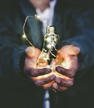 man holding incandescent bulb