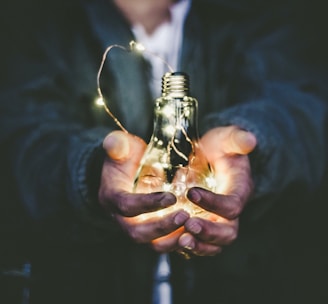 man holding incandescent bulb