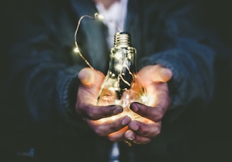 man holding incandescent bulb