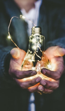 man holding incandescent bulb