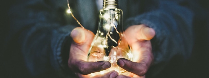 man holding incandescent bulb