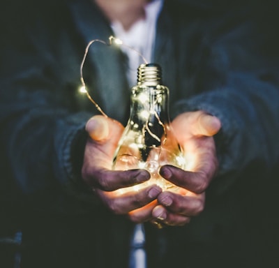 man holding incandescent bulb