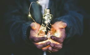 man holding incandescent bulb