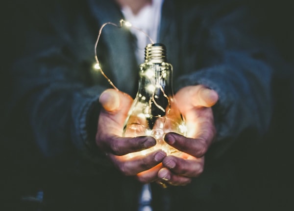 man holding incandescent bulb