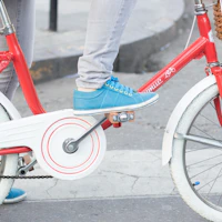 A rider shifting gears on a bike wearing stylish sneakers protected by the gear shield.