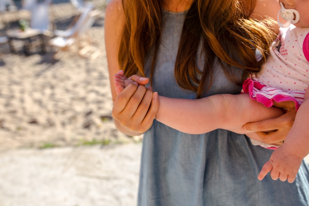 Una donna che tiene in braccio il suo bambino.