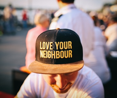 man wearing black cap with love your neighbour print during daytime