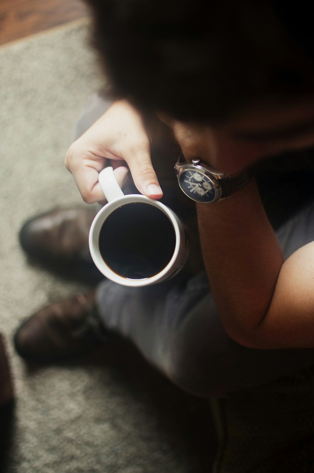 Persona sentada en el sofá sosteniendo una taza de café