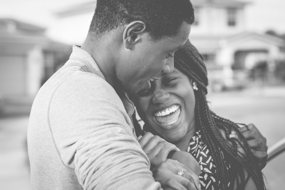 Black and white picture of man and woman holding each other and laughing in Fort Pierce
