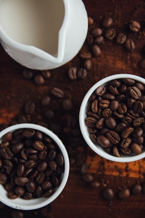 Overhead view of various coffee tools and freshly roasted beans arranged artistically on a rustic table.