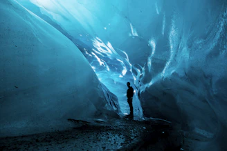 person standing in ice cave at daytime