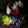 red grapes on clear glass wine