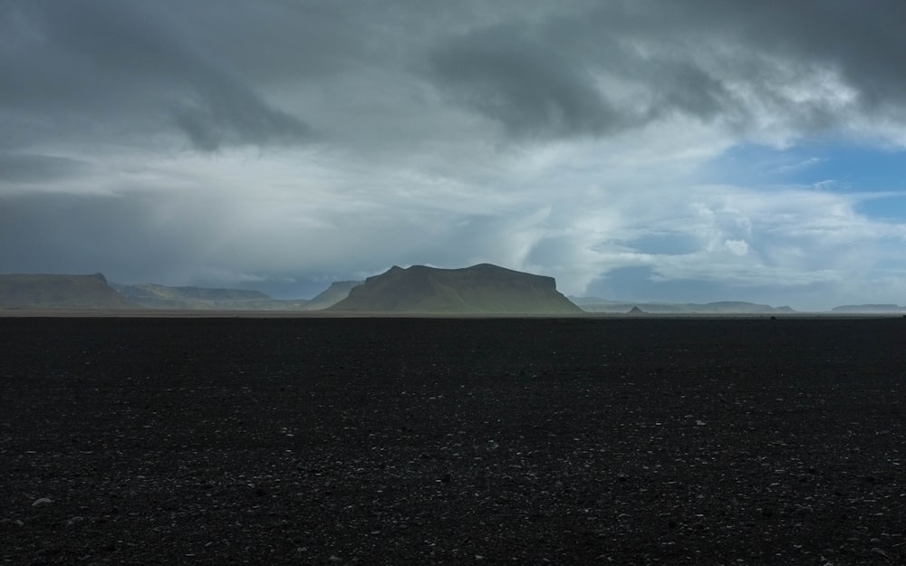 shallow focus photography of black mountain under sky