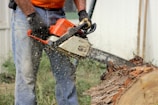 a man using a chainsaw to cut a tree