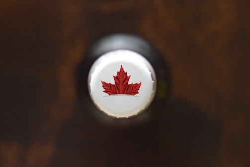 Close-up of the intricate design details on a Caroma bottle cap with a blurred car interior background.