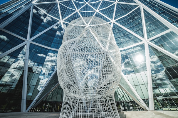 a large white sculpture in front of a building