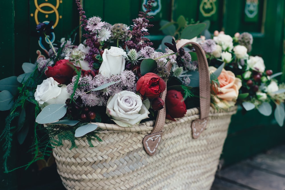 white and red flowers on wicker bag