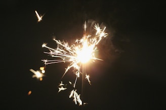 A vibrant spark igniting a flame against a dark background, symbolizing the start of inspiration.