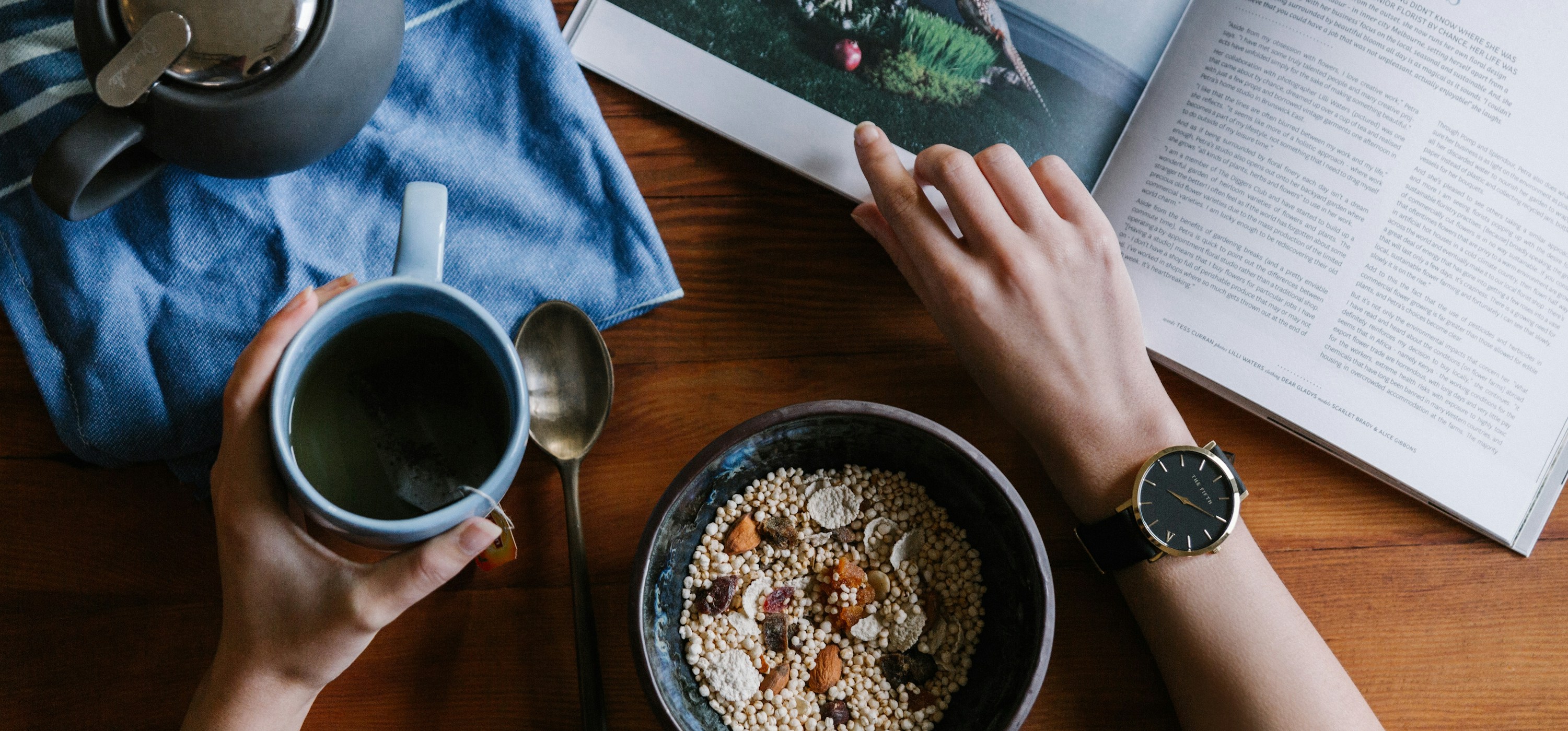 person holding blue ceramic mug and white magazine by THE 5TH (https://unsplash.com/@the5th)