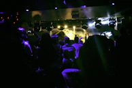 Wide shot of the venue filled with an energetic crowd under dynamic lighting.