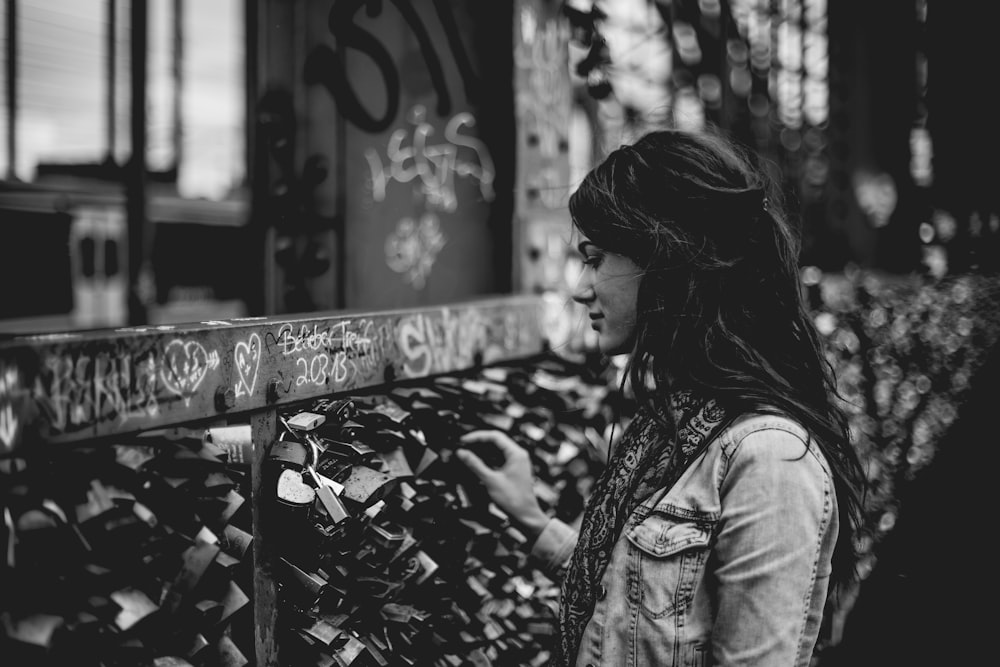 woman holding padlock on bridge