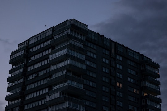 A sleek drone shot capturing a dark, high-end luxury apartment building in Bogotá at dusk.