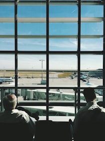 two men sitting in front of glass window during daytime