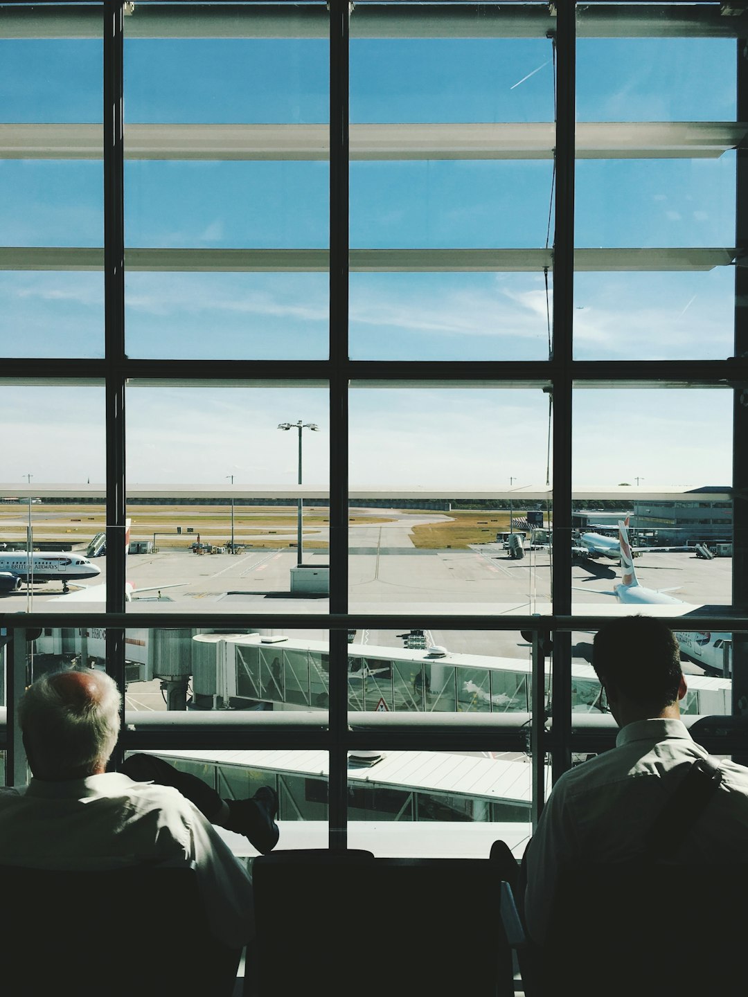 two men sitting in front of glass window during daytime