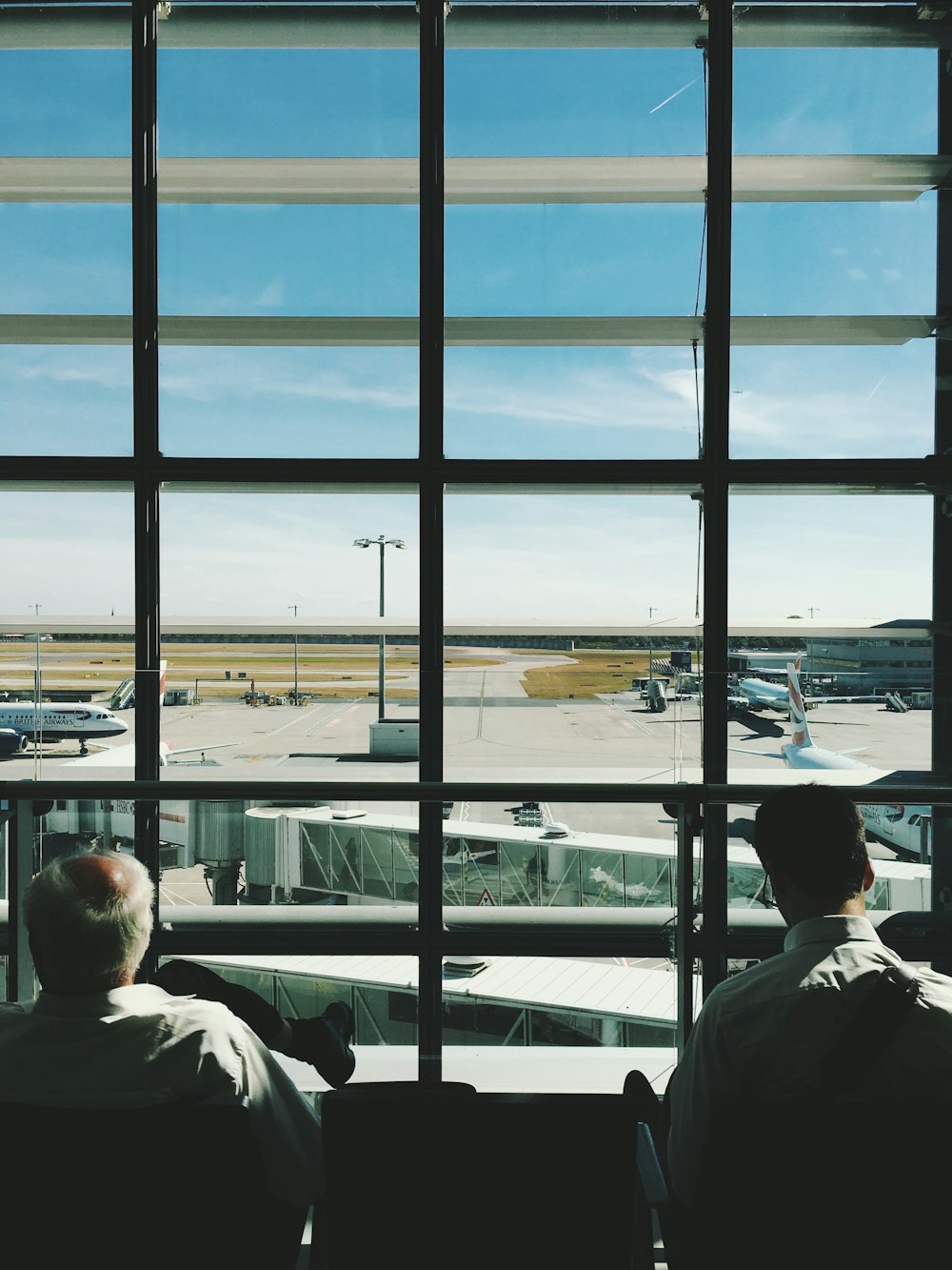 two men sitting in front of glass window during daytime