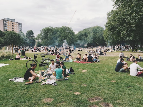 A smiling group of friends enjoying an outdoor picnic in a sunny park.