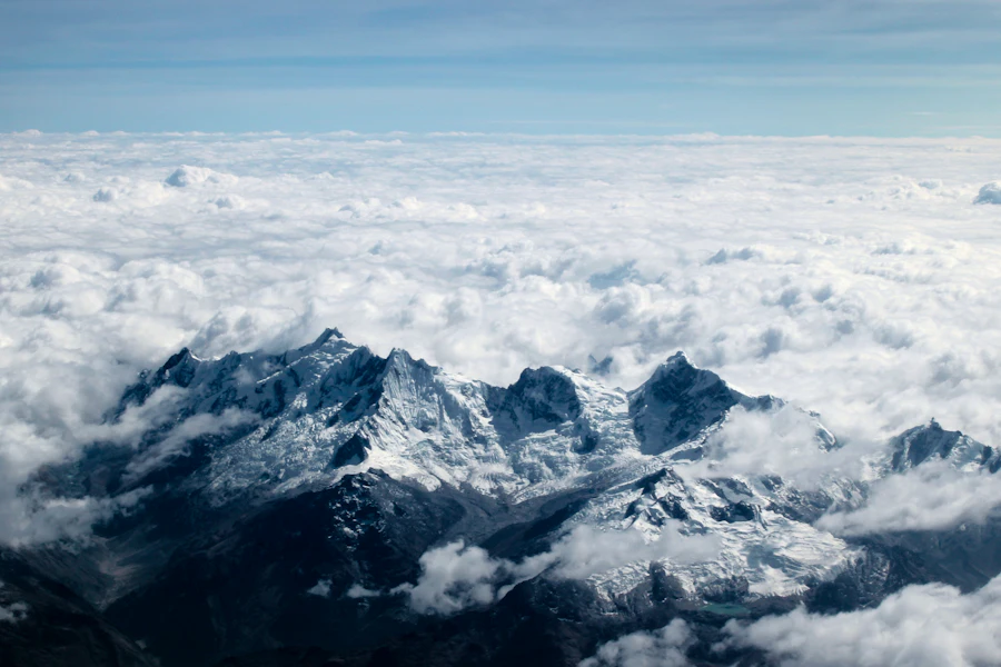 Aerial view of a snow-covered mountain massif under deep blue shadow
