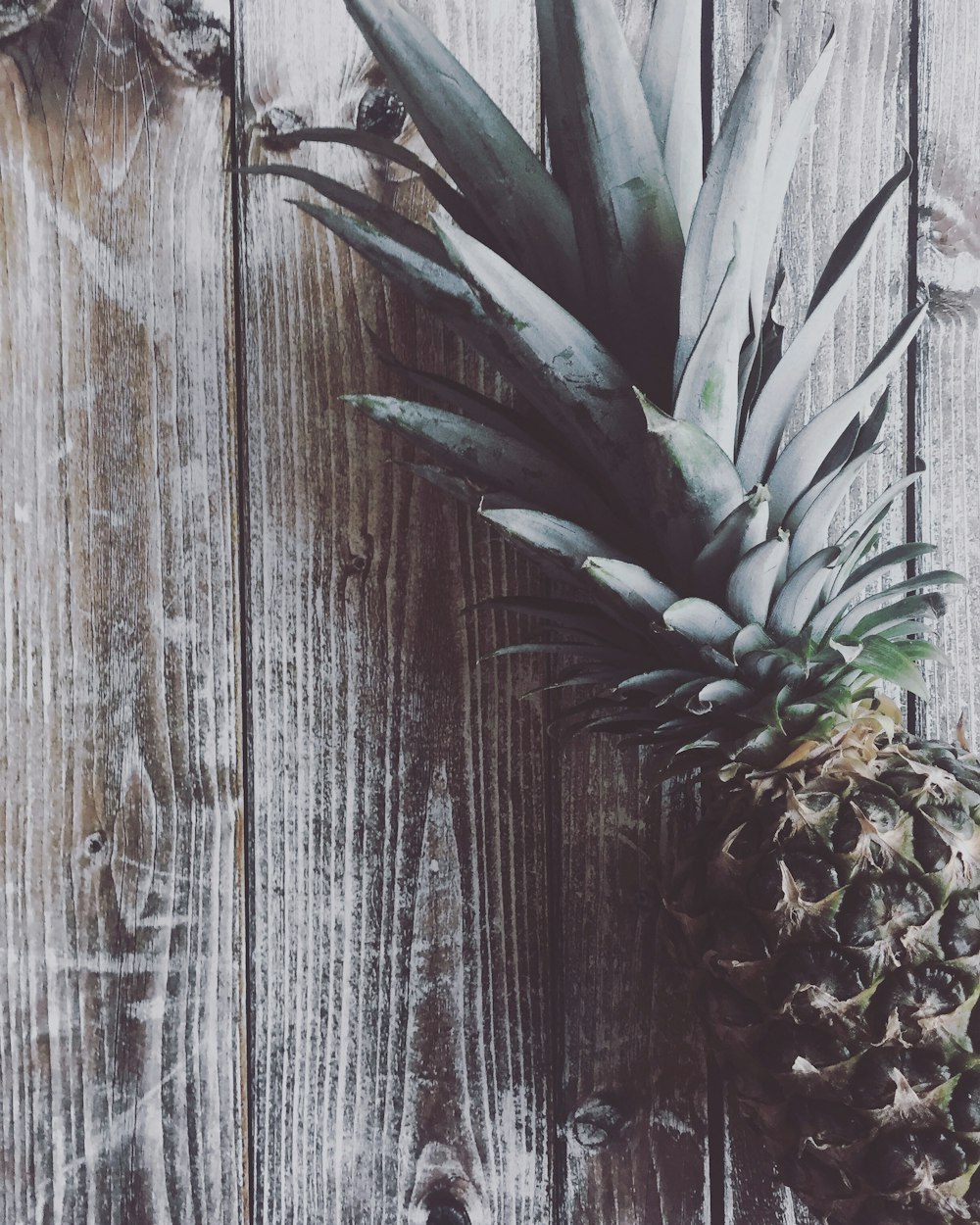 un ananas assis sur une table en bois