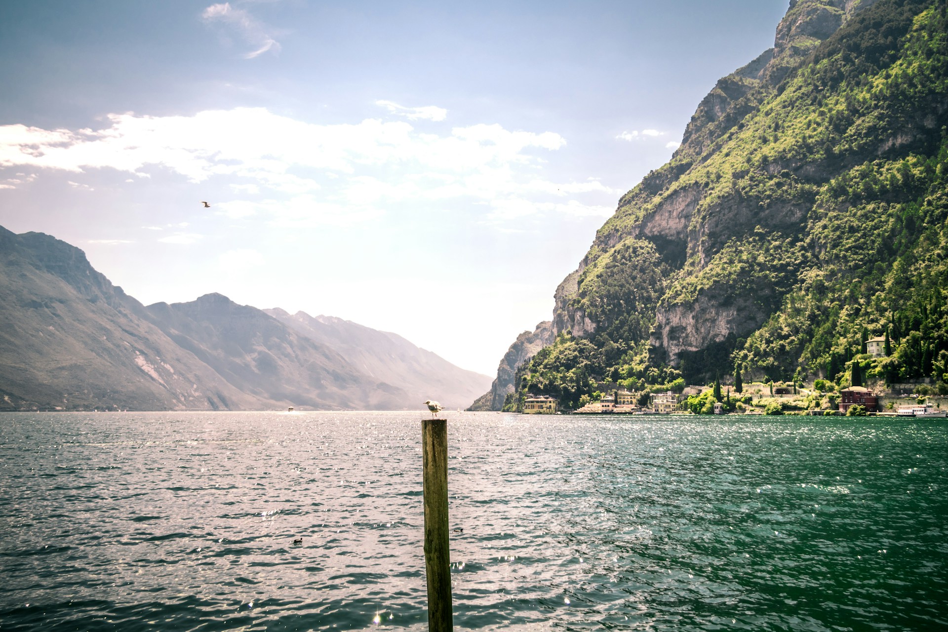 green mountain beside body of water during daytime